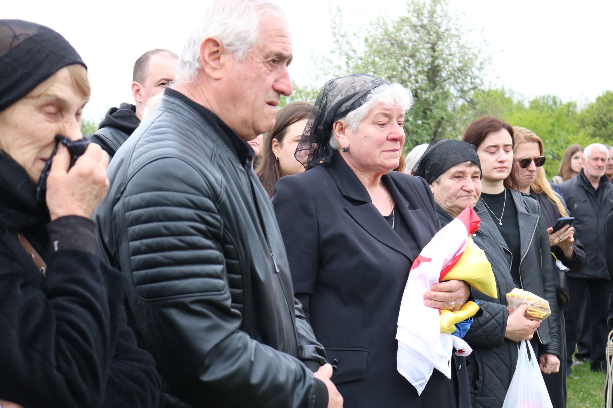 Мама Реваза Гегечкорі тримає прапори України та Грузії, якими була вкрита труна захисника