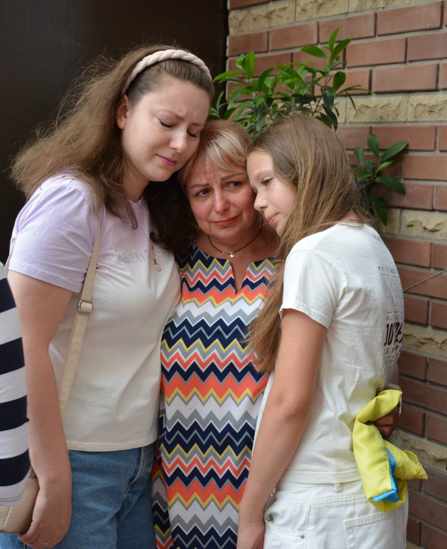 Дружина і доньки захисника під час церемонії відкриття меморіальної дошки