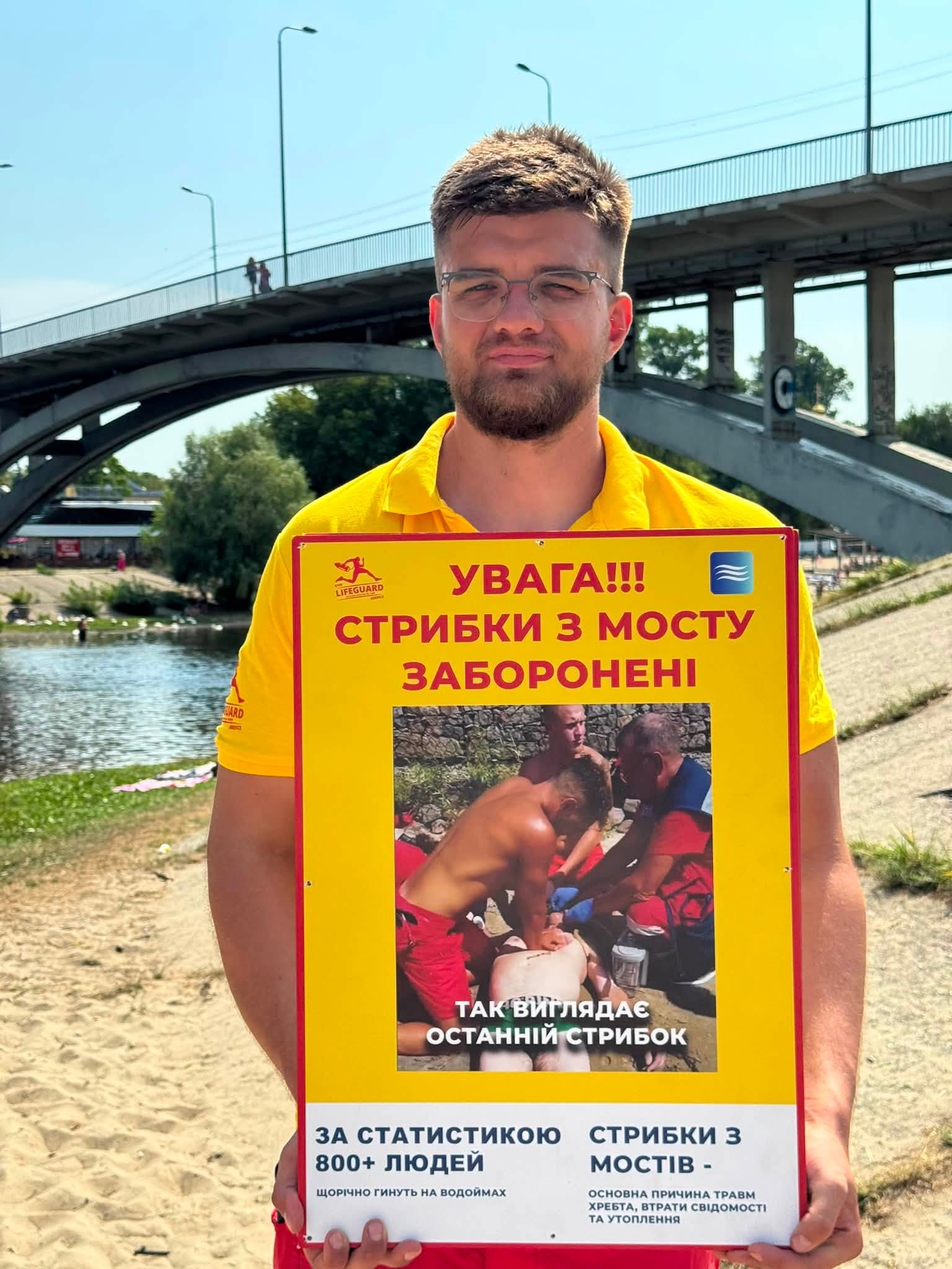 Рятувальник тримає попереджувальну табличку, які становили у Гідропарку 