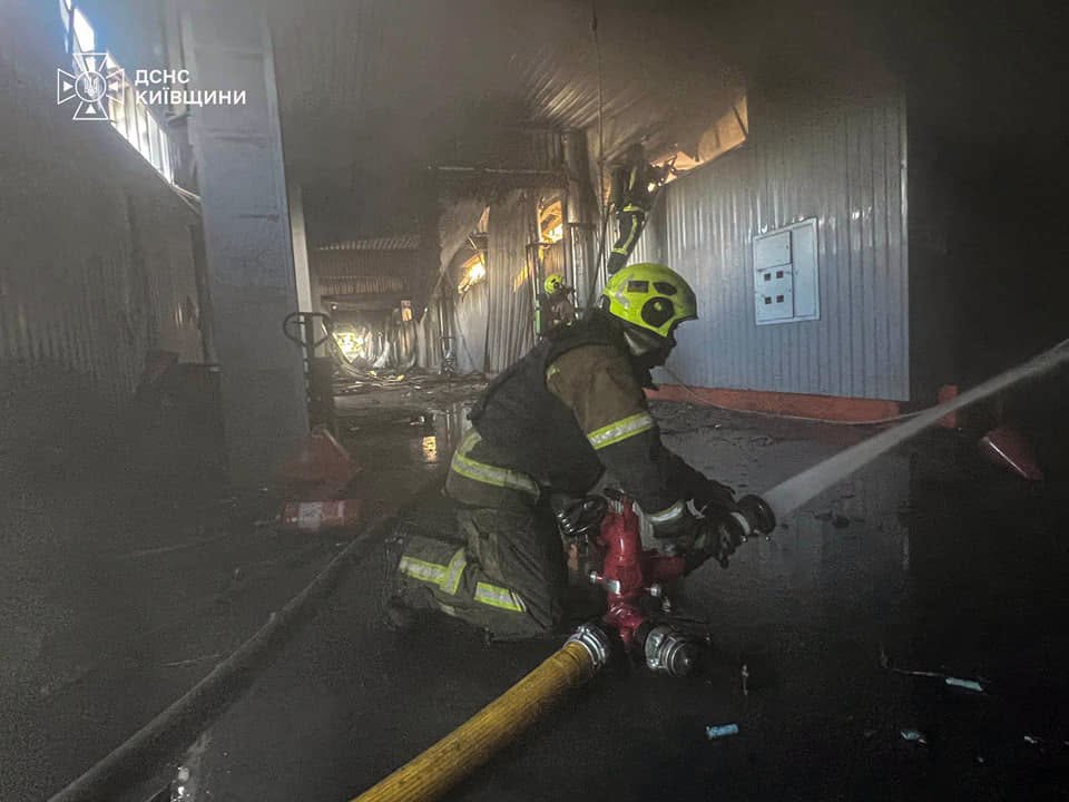 Рятувальник проливає приміщення складу