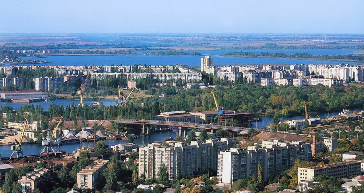 Великий спальний мікрорайон Корабел у світлі довоєнні часи. З містом його поєднував міст, який у 2025 році через російські обстріли став фактично непридатним. Мікрорайон майже відрізаний від основної частини Херсона