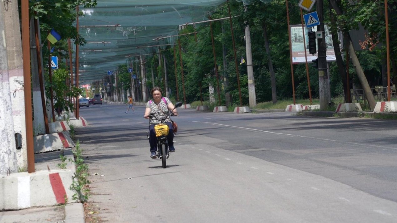Типова картинка в Херсоні: люди пересуваються вулицями, які затягнуто антидроновими сітками