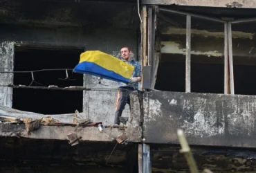 Символ незламності: житель Києва вивісив прапор на балконі понівеченого балістикою будинку