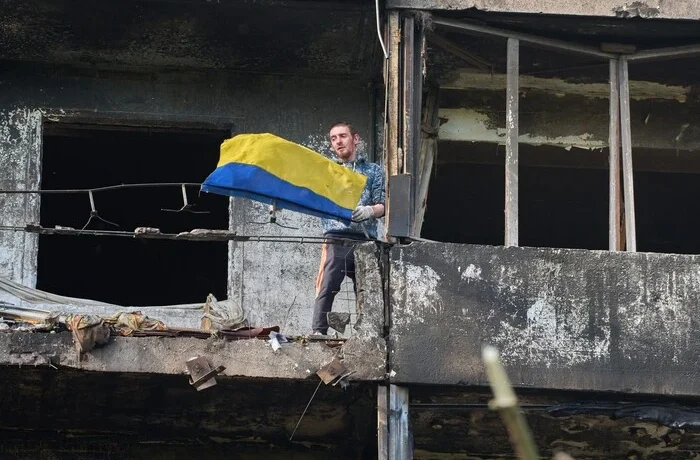 Символ незламності: житель Києва вивісив прапор на балконі понівеченого балістикою будинку