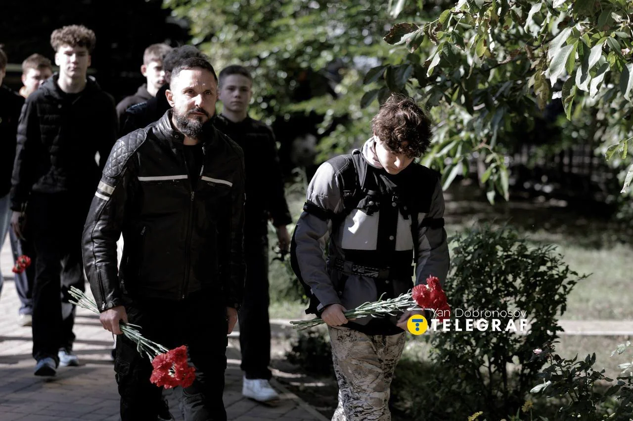 Люди несуть на могилу живі квіти